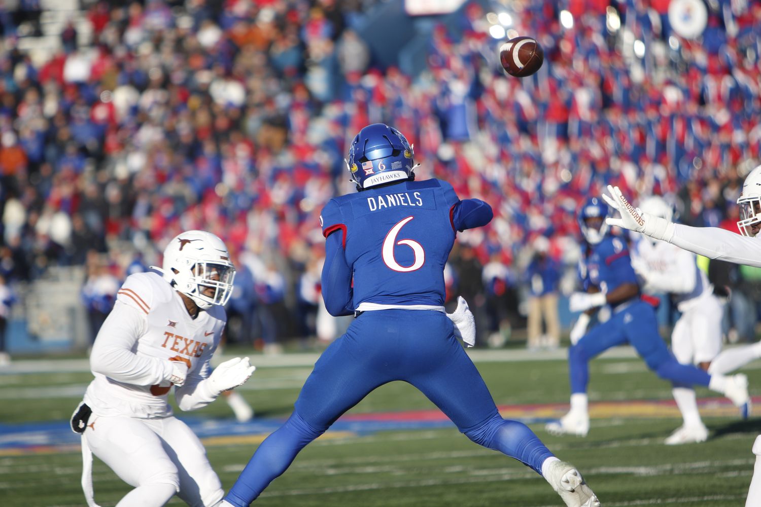 Kansas Jayhawks quarterback Jalon Daniels throws a pass while on the run in the first half against the Texas Longhorns in David Booth Kansas Memorial Stadium on November 19, 2022.