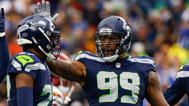 Seattle Seahawks cornerback Riq Woolen (27) and defensive end Leonard Williams (99) celebrate following a play against the Washington Commanders during the second quarter at Lumen Field.