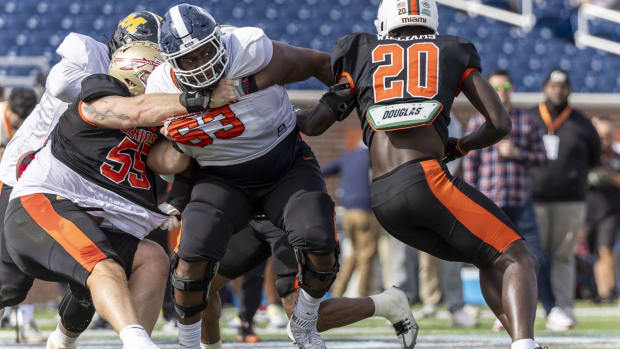 Feb 1, 2024; Mobile, AL, USA; American offensive lineman Christian Haynes of UConn (63) battles with American defensive lineman Braden Fiske of Florida State (55) and American linebacker James Williams of Miami (20) during practice for the American team at Hancock Whitney Stadium. Mandatory Credit: Vasha Hunt-USA TODAY Sports  