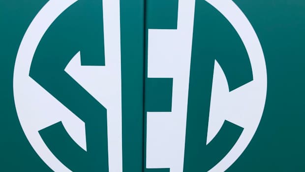 SEC logo in green on softball stadium padding
