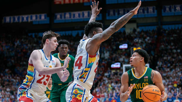 Feb 10, 2024; Lawrence, Kansas, USA; Baylor Bears guard RayJ Dennis (10) looks to pass around Kansas Jayhawks forward K.J. Adams Jr. (24) during the first half at Allen Fieldhouse. Mandatory Credit: William Purnell-USA TODAY Sports  