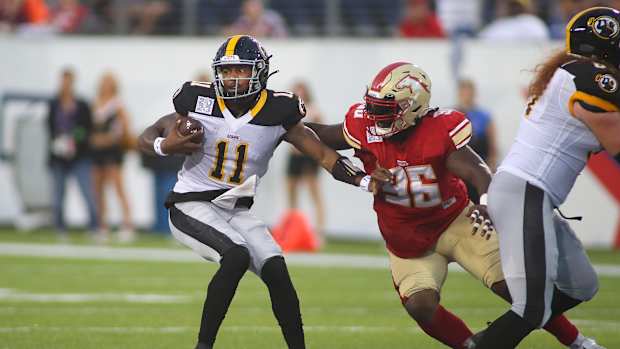 Pittsburgh Maulers Troy Williams (11) attempts to push away from Birmingham Stallions Willie Henry (96) after being trapped in the pocket during the first half of the USFL Championship game Saturday evening at Tom Benson Stadium in Canton, OH.  