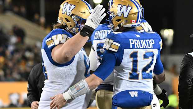 Nov 19, 2023; Hamilton, Ontario, CAN; Winnipeg Blue Bombers quarterback Dakota Prukop (12) celebrates with offensive lineman Liam Dobson (64) after scoring a touchdown against the Montreal Alouettes in the first half at Tim Hortons Field. Mandatory Credit: Dan Hamilton-USA TODAY Sports  
