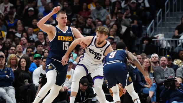 Feb 14, 2024; Denver, Colorado, USA; Denver Nuggets forward Justin Holiday (9) steals the ball away from Sacramento Kings forward Domantas Sabonis (10) as center Nikola Jokic (15) defends in the second quarter at Ball Arena. Mandatory Credit: Ron Chenoy-USA TODAY Sports  