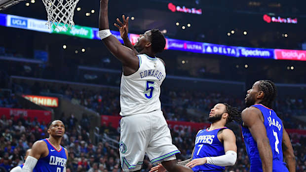 Feb 12, 2024; Los Angeles, California, USA; Minnesota Timberwolves guard Anthony Edwards (5) shoots ahead of Los Angeles Clippers guard Amir Coffey (7) and forward Kawhi Leonard (2) during the first half at Crypto.com Arena.