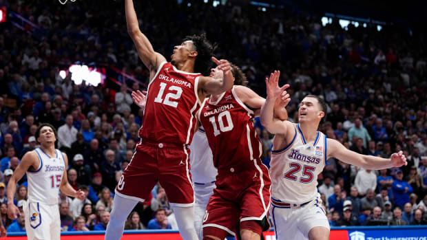 Jan 13, 2024; Lawrence, Kansas, USA; Oklahoma Sooners guard Milos Uzan (12) shoots against the Kansas Jayhawks during the first half at Allen Fieldhouse. Mandatory Credit: Jay Biggerstaff-USA TODAY Sports  