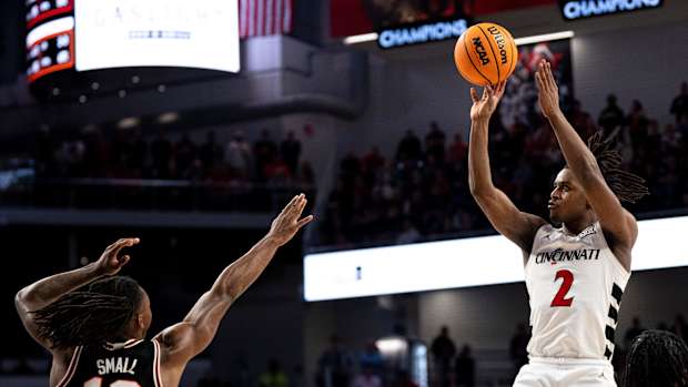 Cincinnati Bearcats guard Jizzle James (2) hits a basket over Oklahoma State Cowboys guard Javon Small (12) in the second half of the NCAA basketball game between Cincinnati Bearcats and Oklahoma State Cowboys at Fifth Third Arena in Cincinnati on Wednesday, Feb. 21, 2024.