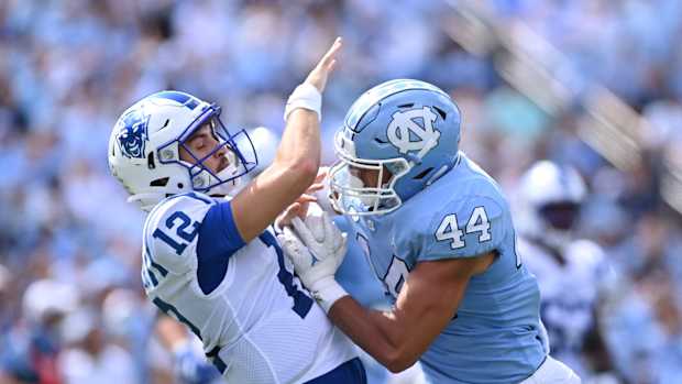 Oct 2, 2021; Chapel Hill, North Carolina, USA; Duke Blue Devils quarterback Gunnar Holmberg (12) is hit by North Carolina Tar Heels linebacker Jeremiah Gemmel (44) as he passes the ball in the second quarter at Kenan Memorial Stadium. Mandatory Credit: Bob Donnan-USA TODAY Sports  