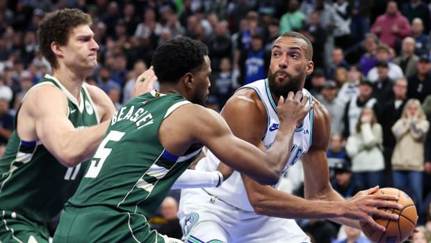 Minnesota Timberwolves center Rudy Gobert (27) controls the ball as Milwaukee Bucks guard Malik Beasley (5) and center Brook Lopez (11) defend during the second half at Target Center in Minneapolis on Feb. 23, 2024.