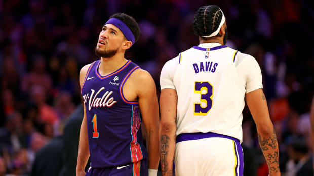 Phoenix Suns guard Devin Booker (1) walks past Los Angeles Lakers forward Anthony Davis (3) during the second quarter at Footprint Center.