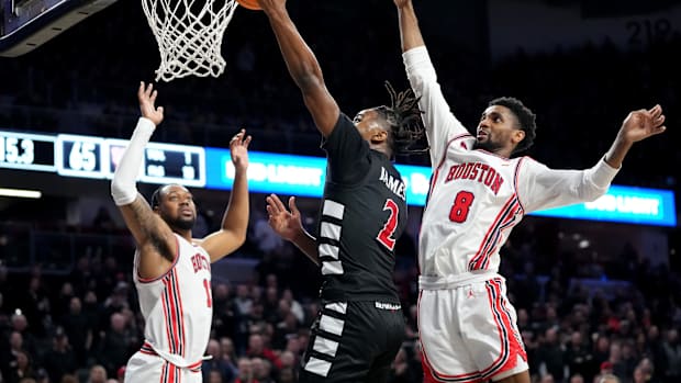 Cincinnati Bearcats guard Jizzle James (2) rises to the basket as Houston Cougars guard Mylik Wilson (8) defends in the second half of an NCAA college basketball game between the Houston Cougars and the Cincinnati Bearcats, Saturday, Feb. 10, 2024, at Fifth Third Arena in Cincinnati.