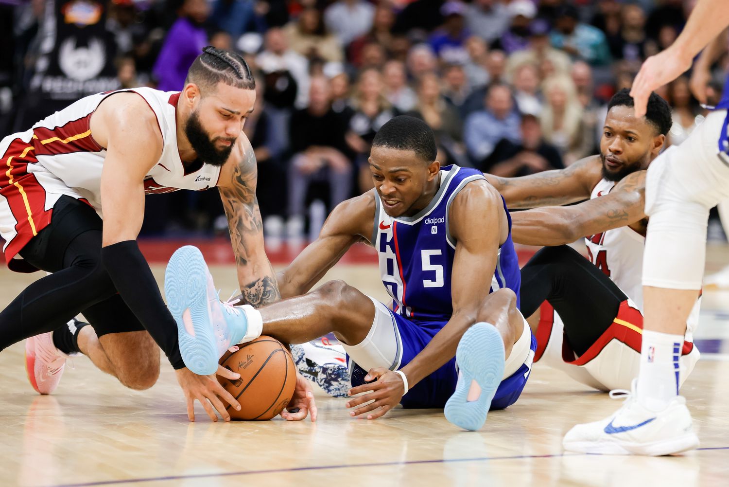 Feb 26, 2024; Sacramento, California, USA; Sacramento Kings guard De'Aaron Fox (5) and Miami Heat forward Caleb Martin (16) fight for the ball during the fourth quarter at Golden 1 Center. Mandatory Credit: Sergio Estrada-USA TODAY Sports  