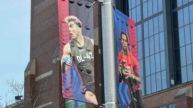 Lukas Van Ness and C.J. Stroud are shown on banners outside Lucas Oil Stadium