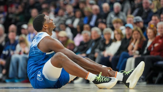 Feb 27, 2024; Minneapolis, Minnesota, USA; Minnesota Timberwolves guard Anthony Edwards (5) holds his ankle on the ground against the San Antonio Spurs in the second quarter at Target Center.