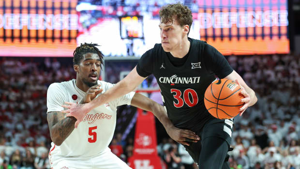 Feb 27, 2024; Houston, Texas, USA; Cincinnati Bearcats forward Viktor Lakhin (30) dribbles the ball as Houston Cougars forward Ja'Vier Francis (5) defends during the first half at Fertitta Center. Mandatory Credit: Troy Taormina-USA TODAY Sports