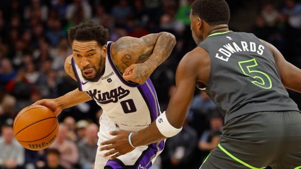 Mar 1, 2024; Minneapolis, Minnesota, USA; Sacramento Kings guard Malik Monk (0) works around Minnesota Timberwolves guard Anthony Edwards (5) in the first quarter at Target Center.