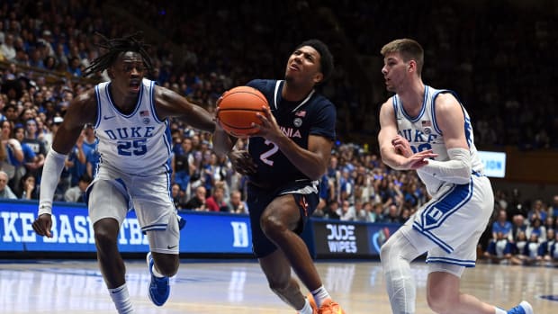 Virginia Cavaliers guard Reece Beekman (2) drives to the basket as Duke Blue Devils forward Mark Mitchell (25) and center Kyle Filipowski (30) defend during the first half at Cameron Indoor Stadium.