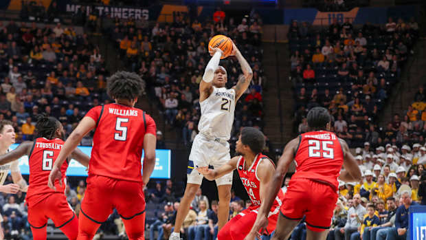 Mountaineers guard RaeQuan Battle (21) shoots a jumper over Texas Tech Red Raiders guard Kerwin Walton (24) during the second half at WVU Coliseum. Mandatory Credit: Ben Queen-USA TODAY Sports