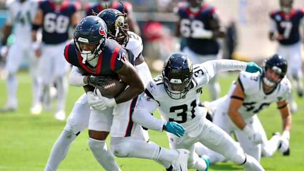 Jacksonville Jaguars safety Rayshawn Jenkins (2) and cornerback Darious Williams (31) try to slow down Houston Texans wide receiver Nico Collins (12) as he runs for a first down late in the second quarter. The Jacksonville Jaguars hosted the Houston Texans at EverBank Stadium in Jacksonville, Fla. Sunday, September 24, 2023. The Jaguars trailed 17 to 0 at the end of the first half.