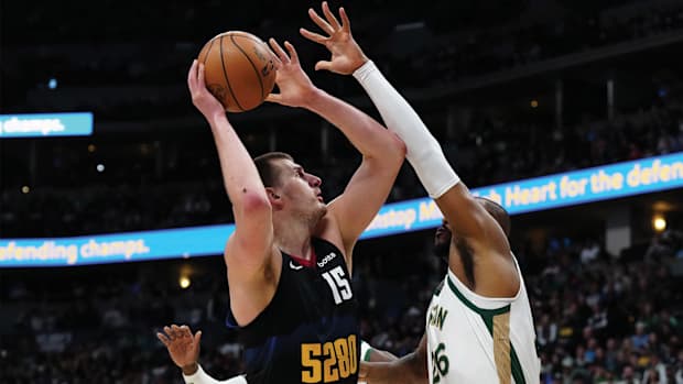 Boston Celtics forward Xavier Tillman defends Denver Nuggets center Nikola Jokić.