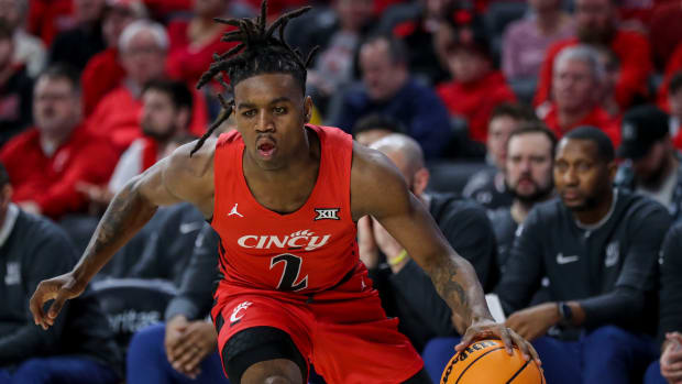 Cincinnati Bearcats guard Day Day Thomas (1) hits a jump shot over West Virginia Mountaineers guard Kerr Kriisa (3) in the first half of the NCAA basketball game between Cincinnati Bearcats and West Virginia Mountaineers at Fifth Third Arena in Cincinnati on Saturday, March 9, 2024.