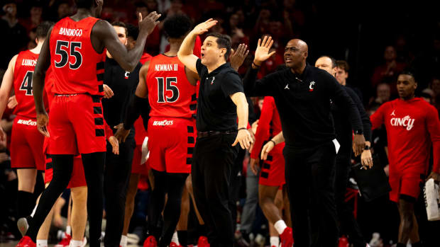 Cincinnati Bearcats head coach Wes Miller high fives Cincinnati Bearcats forward Aziz Bandaogo (55) in the first half of the NCAA basketball game between Cincinnati Bearcats and West Virginia Mountaineers at Fifth Third Arena in Cincinnati on Saturday, March 9, 2024.