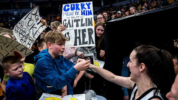 Iowa guard Caitlin Clark (22) gives a fan her headband during the Big Ten Women's Basketball tournament quarterfinals at the Target Center on Friday, March 8, 2024, in Minneapolis, Minn.