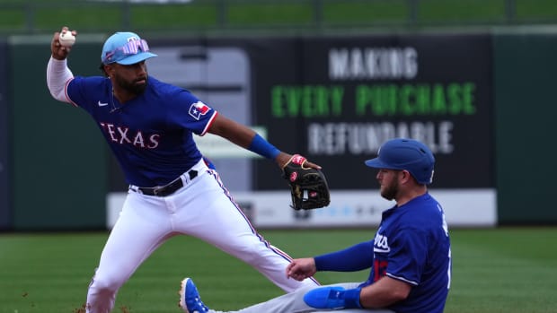 Texas Rangers infielder Ezequiel Duran, left, throws to first base after forcing out Los Angeles Dodgers third baseman Max Muncy at second during a Cactus League game on Feb. 28 at Surprise Stadium.