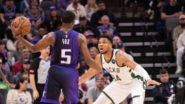 Sacramento Kings guard De'Aaron Fox (5) looks to pass the ball against Milwaukee Bucks forward Giannis Antetokounmpo (34)