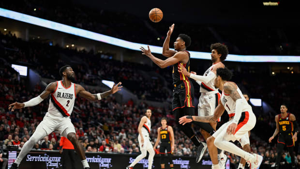 Mar 13, 2024; Portland, Oregon, USA; Atlanta Hawks forward De'Andre Hunter (12) passes the ball during the second half against Portland Trail Blazers guard Matisse Thybulle (4) and center Deandre Ayton (2) at Moda Center. Mandatory Credit: Troy Wayrynen-USA TODAY Sports