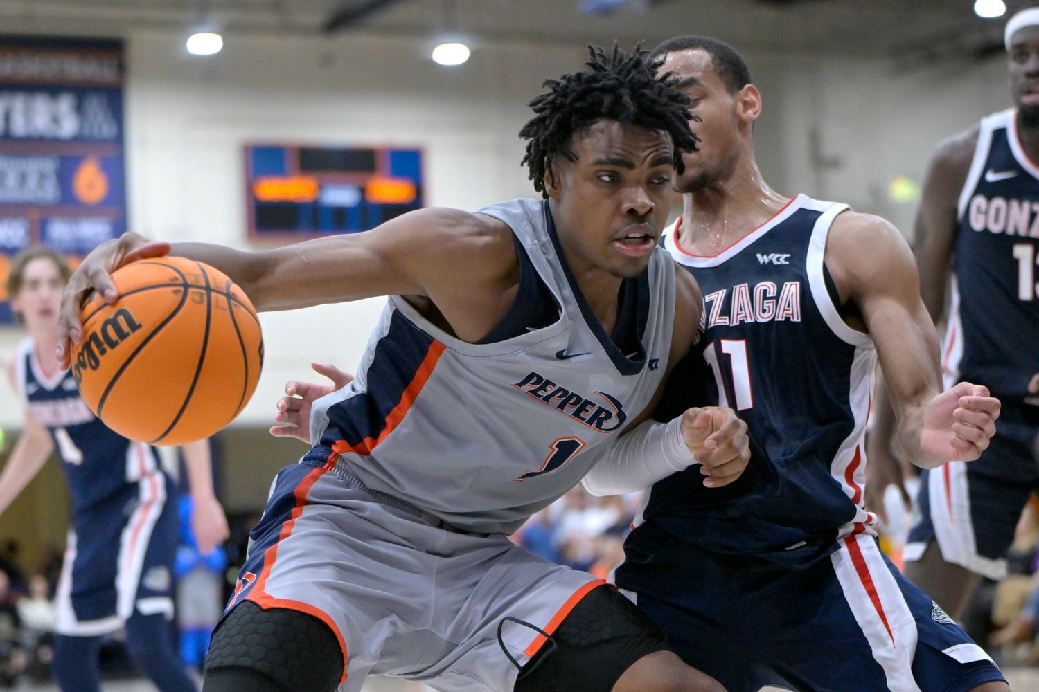 Jan 18, 2024; Malibu, California, USA; Pepperdine Waves guard Michael Ajayi (1) is defended by Gonzaga Bulldogs guard Nolan Hickman (11) in the second half at Firestone Fieldhouse. Mandatory Credit: Jayne Kamin-Oncea-USA TODAY Sports