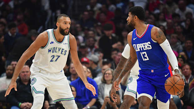 Los Angeles Clippers forward Paul George (13) controls the ball against Minnesota Timberwolves center Rudy Gobert (27) during the first half at Crypto.com Arena in Los Angeles on March 12, 2024.