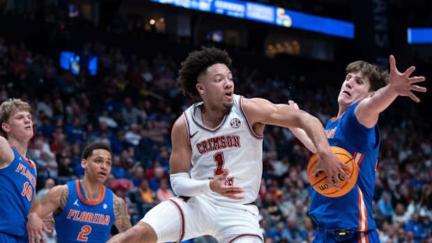 Alabama Crimson Tide guard Mark Sears (1) makes a no-look pass beneath Florida Gators forward Alex Condon (21) during their SEC Men's Basketball Tournament quarterfinal game at Bridgestone Arena in Nashville, Tenn., Friday, March 15, 2024.at Bridgestone Arena in Nashville, Tenn., Friday, March 15, 2024.