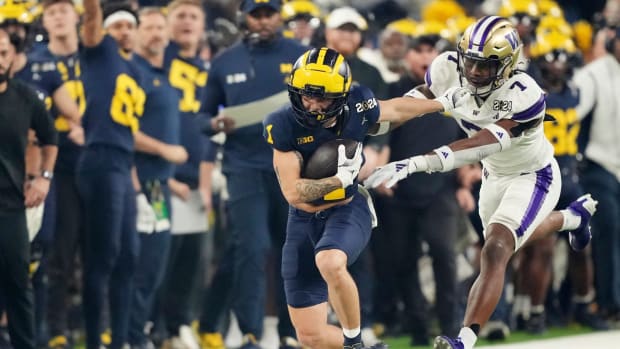 Michigan wide receiver Roman Wilson (1) runs the ball around Washington cornerback Dominique Hampton (7) during the first quarter of the College Football Playoff national championship game against Washington at NRG Stadium in Houston, Texas on Monday, January 8, 2024.  