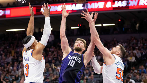 March 16, 2024; Sacramento, California, USA; Sacramento Kings forward Domantas Sabonis (10) reaches for a rebound against New York Knicks guard Josh Hart (3) and center Isaiah Hartenstein (55) during the third quarter at Golden 1 Center. Mandatory Credit: Kyle Terada-USA TODAY Sports  