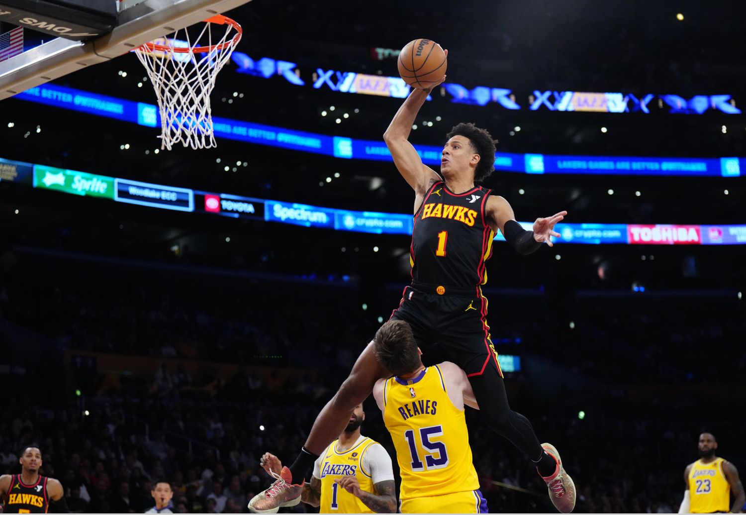 Mar 18, 2024; Los Angeles, California, USA; Atlanta Hawks forward Jalen Johnson (1) dunks the ball over Los Angeles Lakers guard Austin Reaves (15) in the first half at Crypto.com Arena. Mandatory Credit: Kirby Lee-USA TODAY Sports