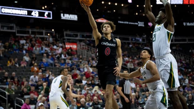 Cincinnati Bearcats guard Dan Skillings Jr. (0) hits a layup as Baylor Bears guard RayJ Dennis (10) and Baylor Bears center Yves Missi (21) guard him in the second half of the Big 12 Conference tournament game between Cincinnati Bearcats and Baylor Bears at T-Mobile Center in Kansas City, Mo., on Thursday, March 14, 2024.  