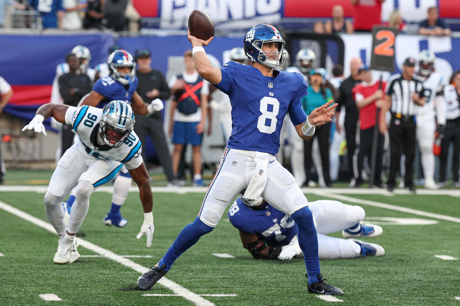 Aug 18, 2023; East Rutherford, New Jersey, USA; New York Giants quarterback Daniel Jones (8) throws the ball during the first quarter as Carolina Panthers linebacker Amare Barno (90) pursues at MetLife Stadium.