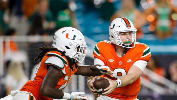 Miami’s Tyler Van Dyke hands the ball off.