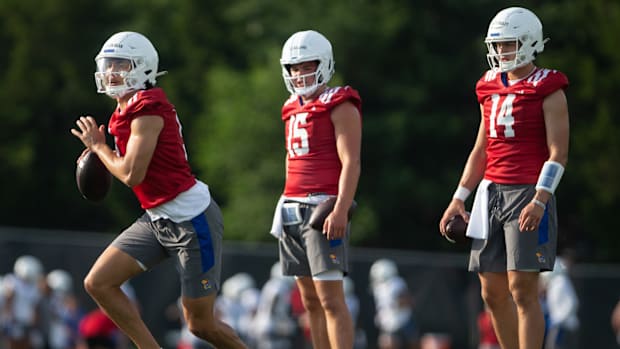 Kansas redshirt senior quarterback Jason Bean (9) works through drills with freshman quarterback Cole Ballard (15) and redshirt freshman quarterback Mikey Pauley (14) during Tuesday's outdoor practice.  