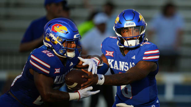 Sep 1, 2023; Lawrence, Kansas, USA; Kansas Jayhawks quarterback Jalon Daniels (6) hands off to running back Daniel Hishaw Jr. (20) during warmups before a game against the Missouri State Bears at David Booth Kansas Memorial Stadium. Mandatory Credit: Jay Biggerstaff-USA TODAY Sports  