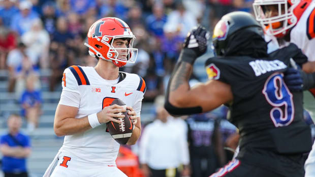 Sep 8, 2023; Lawrence, Kansas, USA; Illinois Fighting Illini quarterback Luke Altmyer (9) drops back to pass against Kansas Jayhawks defensive lineman Austin Booker (9) during the first half at David Booth Kansas Memorial Stadium. Mandatory Credit: Jay Biggerstaff-USA TODAY Sports  
