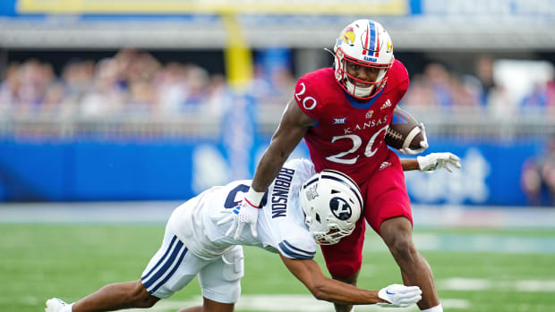 Sep 23, 2023; Lawrence, Kansas, USA; Kansas Jayhawks running back Daniel Hishaw Jr. (20) runs the ball against Brigham Young Cougars cornerback Jakob Robinson (0) during the second half at David Booth Kansas Memorial Stadium. Mandatory Credit: Jay Biggerstaff-USA TODAY Sports  