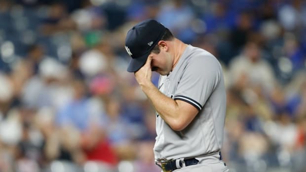 Carlos Rodón touches his head as he prepares to be pulled in the first inning of a Yankees-Royals game.