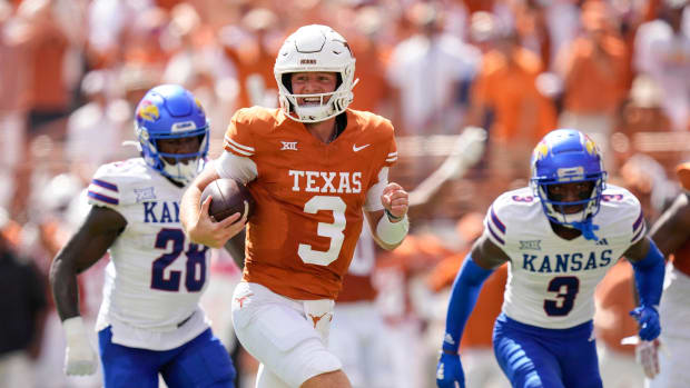 Texas Longhorns quarterback Quinn Ewers runs past Kansas Jayhawks linebacker, left, and cornerback Mello Dotson for a touchdown in the first quarter at Royal-Memorial Stadium on Saturday September 30, 2023.  