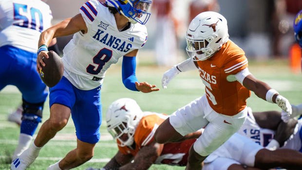 Texas defensive back Malik Muhammad (5) goes to tackle Kansas quarterback Jason Bean (9) in the first quarter of the Longhorns' game against the Kansas Jayhawks, Saturday, Sept. 30 at Darrell K Royal-Texas Memorial Stadium in Austin.