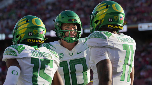 Oregon quarterback Bo Nix, center, congratulates wide receiver Troy Franklin, right, after a touchdown