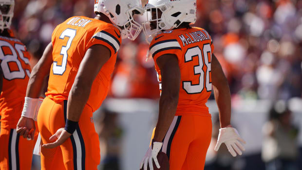 Denver Broncos running back Jaleel McLaughlin (38) celebrates his rushing touchdown with quarterback Russell Wilson (3) in the first quarter against the New York Jets at Empower Field at Mile High.