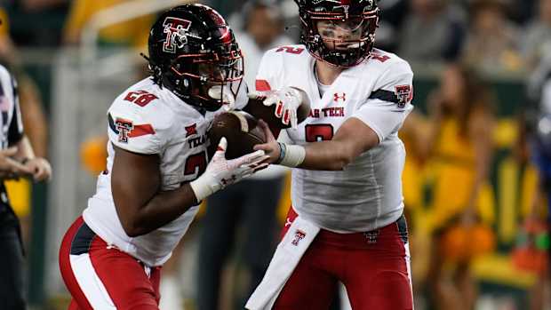 Oct 7, 2023; Waco, Texas, USA; Texas Tech Red Raiders quarterback Behren Morton (2) hands the ball off to Texas Tech Red Raiders running back Tahj Brooks (28) against the Baylor Bears during the second half at McLane Stadium. Mandatory Credit: Chris Jones-USA TODAY Sports  