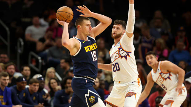 Denver Nuggets center Nikola Jokic (15) controls the ball against Phoenix Suns center Jusuf Nurkic (20) during a preseason game at Footprint Center.